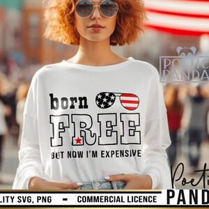May include: White t-shirt with a red, white, and blue American flag design. The text "born FREE BUT NOW I'M EXPENSIVE" is printed on the shirt.
