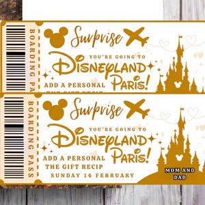 May include: Two gold-colored Disneyland Paris surprise tickets. Each ticket features a Mickey Mouse head, an airplane, and a castle silhouette. Text includes "Surprise," "You're going to Disneyland Paris!" and "Mom and Dad."