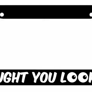 May include: Black license plate frame with white text that reads "CAUGHT YOU LOOKIN'" with two white eyes.