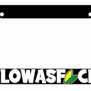 May include: Black license plate frame with white text that reads "SLOW ASF CK" and a yellow and green symbol.