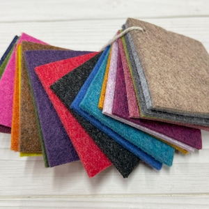 May include: A fan-shaped arrangement of 15 felt squares in various colors, including red, orange, yellow, green, blue, purple, pink, and brown. The felt squares are arranged in a gradient pattern, with the darkest colors at the bottom and the lightest colors at the top.