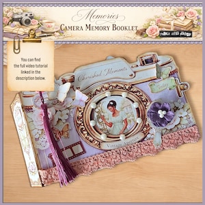 May include: A decorative camera-shaped memory booklet with a vintage aesthetic. The booklet features a central circular image of a woman, adorned with pearls, and the words "Cherished Moments" and "Vintage Aperture." It includes a purple tassel and the text "You can find the full video tutorial linked in the description below."