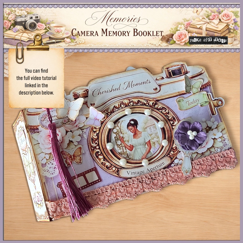 May include: A decorative camera-shaped memory booklet with a vintage aesthetic. The booklet features a central circular image of a woman, adorned with pearls, and the words "Cherished Moments" and "Vintage Aperture." It includes a purple tassel and the text "You can find the full video tutorial linked in the description below."
