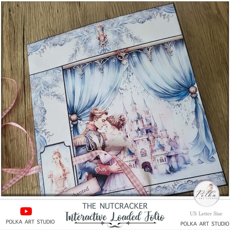 Op de afbeelding: Een blauw en wit interactief geladen folio met een aquarel-illustratie van een dansend stel voor een kasteel. Het folio is getiteld "The Nutcracker Interactive Loaded Folio" en is gelabeld "US Letter Size".
