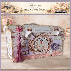 Può includere: Un libretto di ricordi decorativo a forma di macchina fotografica. Le parole "Memories" e "Camera Memory Booklet" sono in alto. La macchina fotografica è decorata con farfalle, fiori e un nappa. Sono visibili anche le parole "Cherished Moments" e "Vintage Aperture".