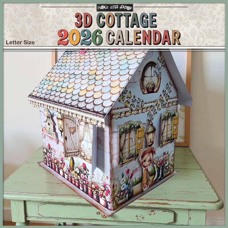 May include: A 3D cottage calendar for 2026. The paper house has a colorful roof, windows, and a door. The cottage is decorated with floral patterns and a small figure of a girl. The words "3D Cottage 2026 Calendar" are printed on the top.