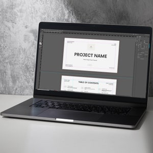 May include: A laptop computer screen displaying a presentation with the title "PROJECT NAME" and a "TABLE OF CONTENTS" section.