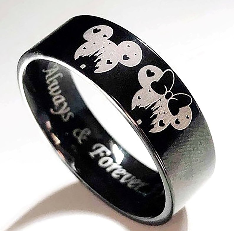 May include: Black ring with a silver engraving of Mickey and Minnie Mouse with hearts. The ring has the words "Always & Forever" engraved on the band.