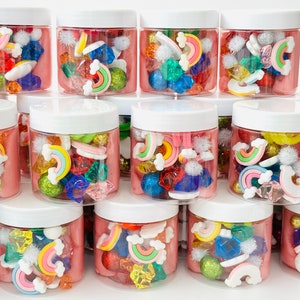 May include: Multiple clear plastic jars filled with pink slime and colorful rainbow-shaped charms, pom poms, and gems.