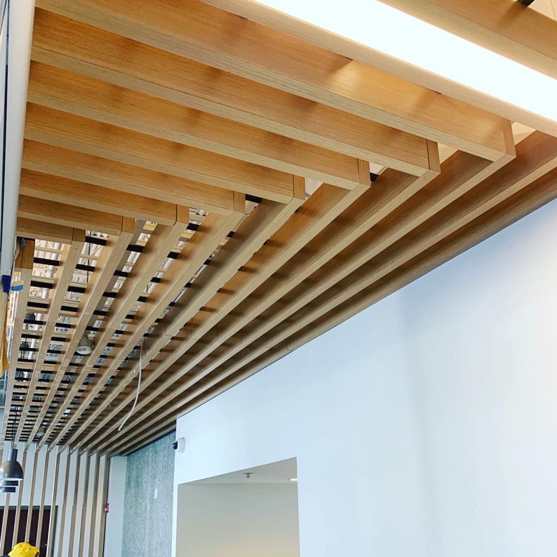 May include: A wooden ceiling with a grid pattern of beams. The beams are arranged in a diagonal pattern, creating a modern and stylish look.