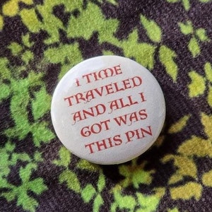 May include: A white button with red text that reads "I Time Traveled And All I Got Was This Pin".