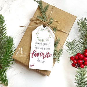 May include: A white gift tag with a green wreath and red berries. The tag says "these are a few of your favorite things" and "from:" in red text.