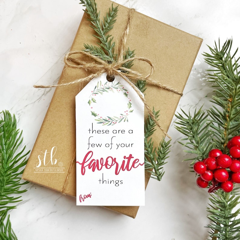 May include: A white gift tag with a green wreath and red berries. The tag says "these are a few of your favorite things" and "from".