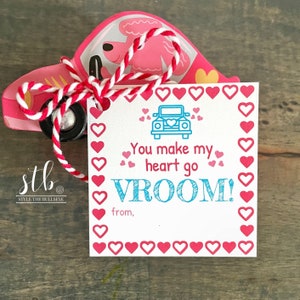 May include: A white card with a red border of hearts. The card says "You make my heart go VROOM!" with a blue car graphic and a space to write "from,".