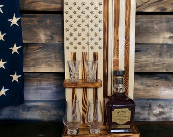 May include: Wooden American flag liquor holder with a bottle of Jack Daniel's Tennessee Whiskey and four shot glasses.