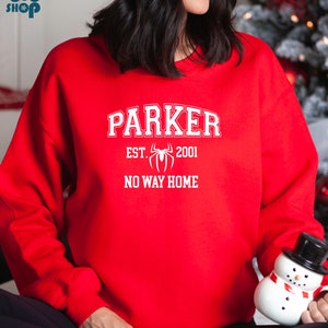 May include: Red sweatshirt with white text that reads "Parker Est. 2001 No Way Home" with a white spider graphic.