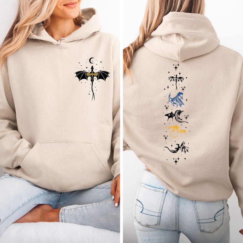 May include: Beige hoodie with a front pocket and a dragon graphic. The front features a black and gold dragon with a crescent moon and stars. The back has a vertical line of dragon illustrations in various colors, including blue and yellow.