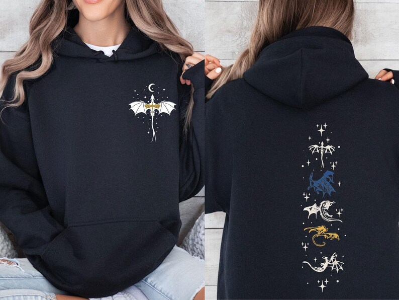 May include: Black hooded sweatshirt with a dragon design. The front features a white and gold dragon with a crescent moon and stars. The back displays a vertical arrangement of various dragon illustrations in white, blue, gold, and white.