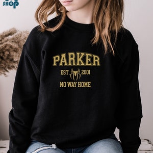 May include: Black sweatshirt with a gold graphic design that says "Parker Est. 2001" with a spider graphic and "No Way Home" underneath.