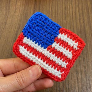 May include: A small crocheted American flag in red, white and blue.