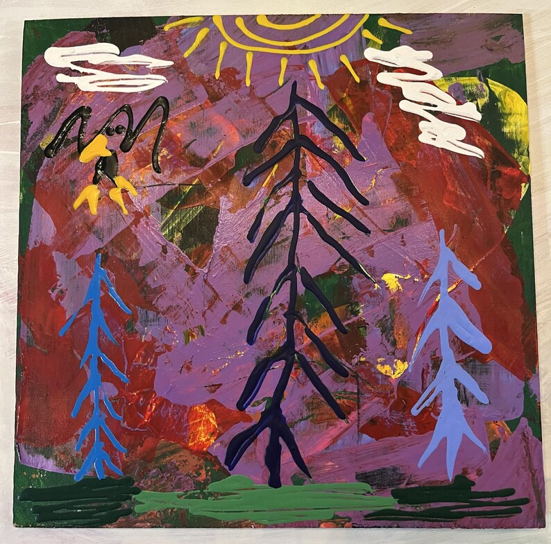 May include: Abstract painting on a wooden canvas with a purple, red, and green background. The painting features a yellow sun, white clouds, and three trees in blue, black, and purple.