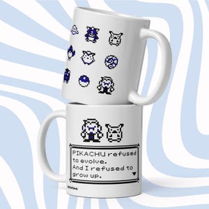 Op de afbeelding: Twee witte keramische mokken op elkaar gestapeld. De bovenste mok heeft blauwe pixelachtige karakterontwerpen. De onderste mok heeft pixelachtige karakters en de tekst "PIKACHU refused to evolve. And I refused to grow up."