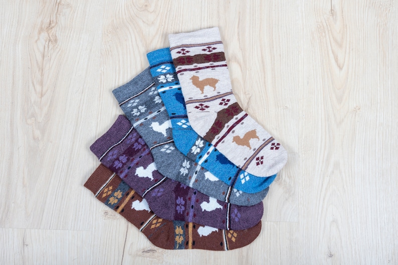 Pu&ograve; includere: Cinque paia di calzini con un designo a motivi che presenta un piccolo animale. I calzini sono in tonalit&agrave; marrone, viola, grigio, blu e bianco.