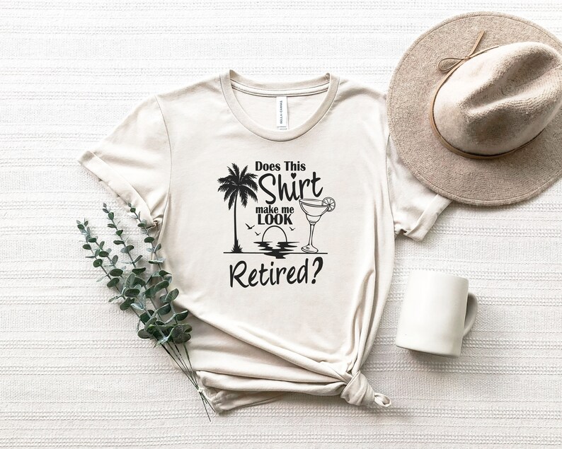 Może przedstawiać: Beżowa koszulka z czarnym nadrukiem palmy, szklanki z margaritą i tekstem "Does This Shirt Make Me Look Retired?"