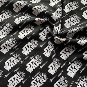 Könnte beinhalten: Schwarzer Stoff mit einem weißen, sich wiederholenden Muster der Worte "Star Wars" in einer verwitterten Schrift.