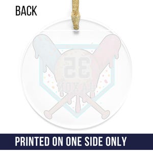 May include: Clear, round ornament with a baseball-themed design. The ornament features a baseball with the number 26, crossed bats, and the text "MOXAL". The ornament has a gold ribbon for hanging. The text "PRINTED ON ONE SIDE ONLY" is at the bottom.