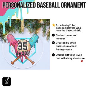 May include: A clear, round baseball ornament with a baseball-themed design. The ornament features a baseball with the number "35" and the name "JAXON". Two crossed bats are below the baseball. The ornament has a gold string for hanging.