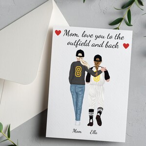 May include: A card with a drawing of two people wearing baseball uniforms. The text on the card reads "Mom, love you to the outfield and back".