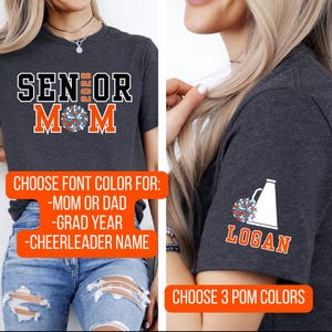 K&ouml;nnte beinhalten: Dunkelgraue T-Shirts mit Cheerleading-Designs. Ein Shirt tr&auml;gt die Aufschrift "SENIOR MOM 2026" in Schwarz und Orange. Das andere Shirt hat eine Megaphon- und Pompon-Grafik mit dem Namen "LOGAN". Der Text "CHOOSE FONT COLOR" ist ebenfalls sichtbar.