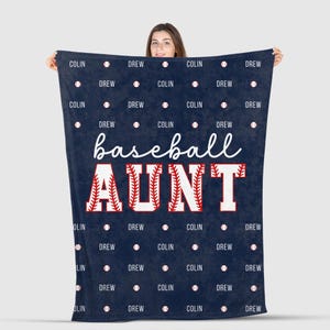 May include: Navy blue baseball blanket with the words "baseball AUNT" in white and red. The names "Colin" and "Drew" are repeated with baseballs on the blanket.