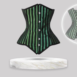 May include: A corset featuring vertical black and green stripes with a front busk closure consisting of silver metal clasps. The garment has black trim along the edges and a back panel with black lacing and silver grommets shown in a circular inset.