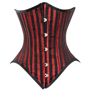 May include: A red and black striped corset with a busk closure and metal eyelets. The corset is made of a satin-like fabric and has a pointed shape.