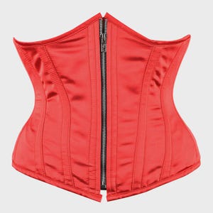 May include: A bright red satin corset featuring a vertical silver-toned metal zipper closure down the center front. The garment is constructed with multiple vertical stitched panels that follow the contoured shape of the bodice.