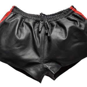 May include: Black leather shorts with red side stripes. The shorts have an elastic waistband with a drawstring.