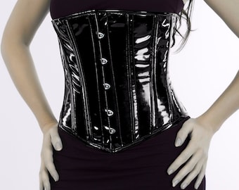May include: A black patent leather corset with a busk closure and metal eyelets. The corset has a shiny finish and a smooth texture.