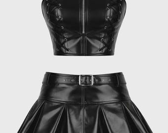Completo corsetto in PVC nero, minigonna plissettata e bustier in vinile per festival e rave.
