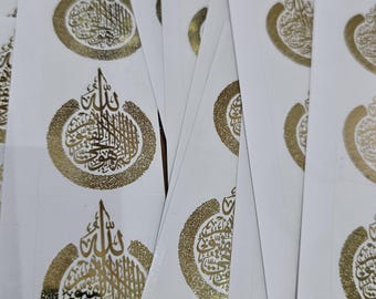 May include: A stack of white paper stickers with gold foil calligraphy. The calligraphy is in Arabic and reads "Allah".