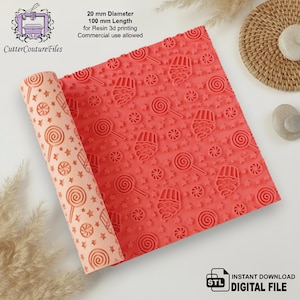 May include: A coral-colored, rolled-up resin 3D printing sheet with a repeating pattern of lollipops, stars, and cotton candy. The sheet is 100 mm long and 20 mm in diameter. The text on the image says "Commercial use allowed."