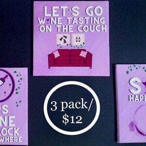 May include: Three purple coasters with wine-themed sayings.  The first coaster says, 