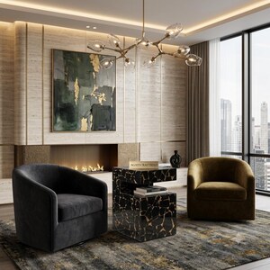 May include: A black, cube-shaped side table with a cracked stone pattern and gold veining, featuring the text AGATECRAFTSIND on top. It is positioned between a dark gray velvet armchair and a mustard yellow velvet armchair in a room.