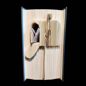 May include: A book with pages folded into the shape of a mailbox. The mailbox is made of paper and has a blue and white design. The mailbox is open and has a piece of paper inside.