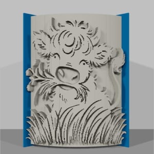 May include: A light gray, carved wooden panel featuring a cow's head with a floral design and grass at the bottom. The panel is framed by blue edges, creating a three-dimensional effect.
