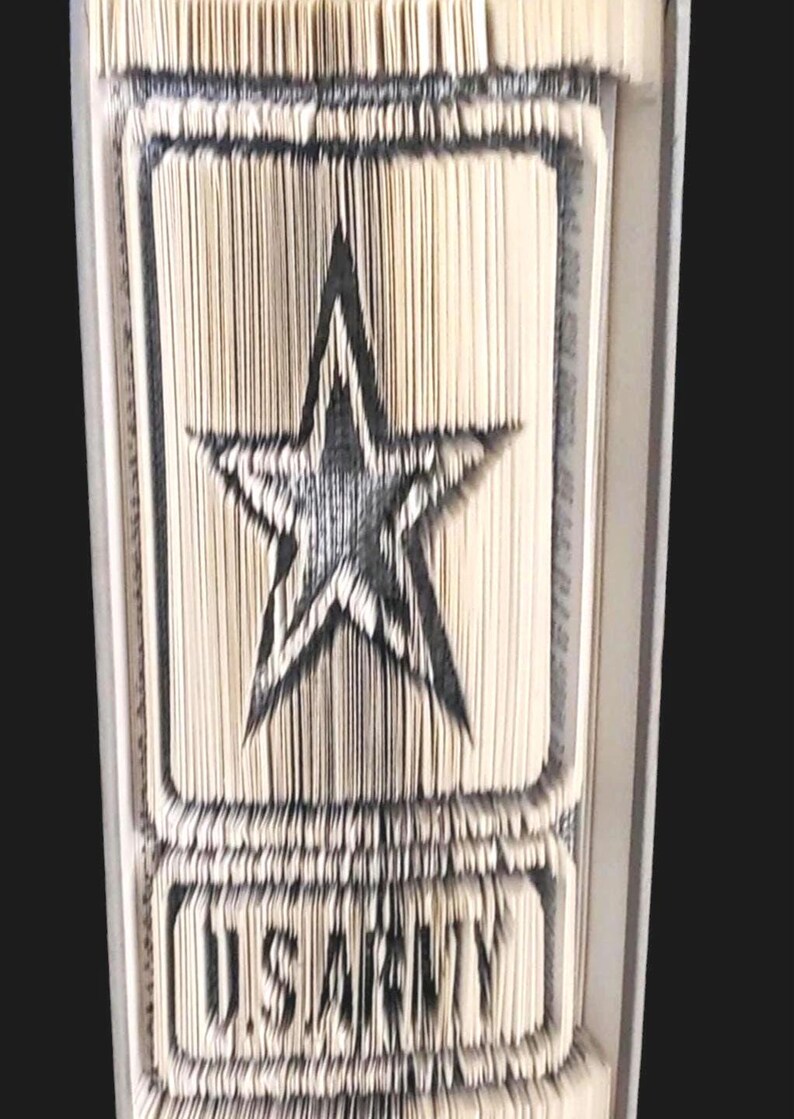 Puede incluir: Un libro doblado en forma de estrella de cinco puntas con las palabras "U.S. ARMY" debajo.
