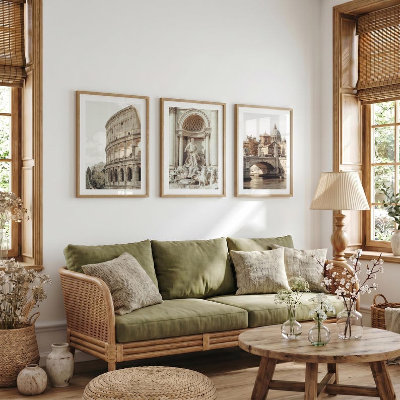 May include: A set of three framed wall art prints depicting the Colosseum, the Trevi Fountain, and a bridge in Rome, displayed above an olive green sofa with a rattan frame, accompanied by a wooden coffee table and a lamp with a pleated shade.