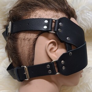 Pu&ograve; includere: Benda per gli occhi in pelle nera con cinturini regolabili e fibbie color argento. La benda presenta due ampie fasce che coprono gli occhi e un cinturino che gira intorno alla testa. Per giochi sensoriali.