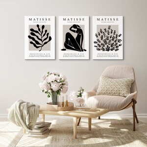 May include: Three black and white Matisse prints with the title "PAPIERS DECOUPES" and the artist's name "MATISSE" in white text. The prints feature a stylized leaf, a woman's figure, and a cluster of leaves.